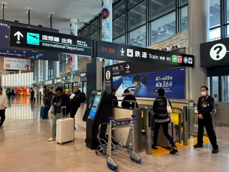 tokyo narita airport arrivals hall sign above escalator